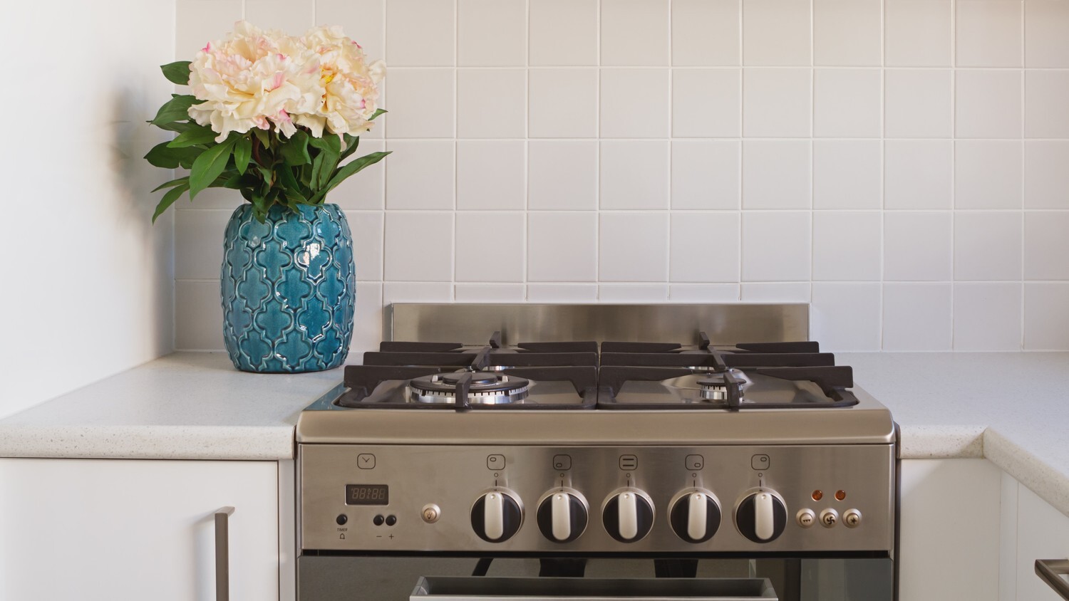 A professional stove installation with a sleek stainless steel stove and range hood in a modern kitchen.