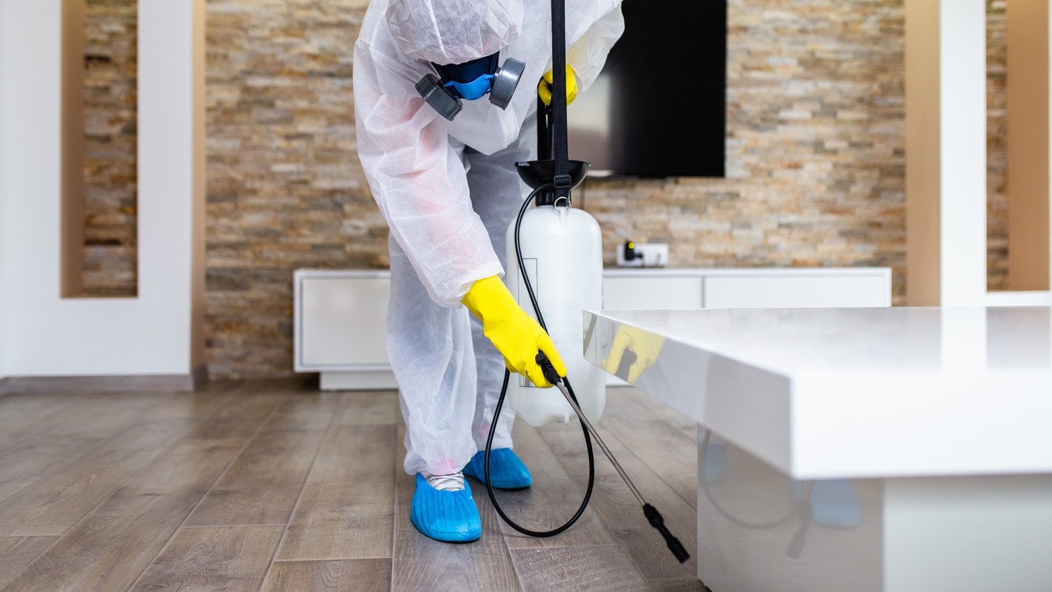 A professional pest control technician wearing protective gear, inspecting a residential area for pests.