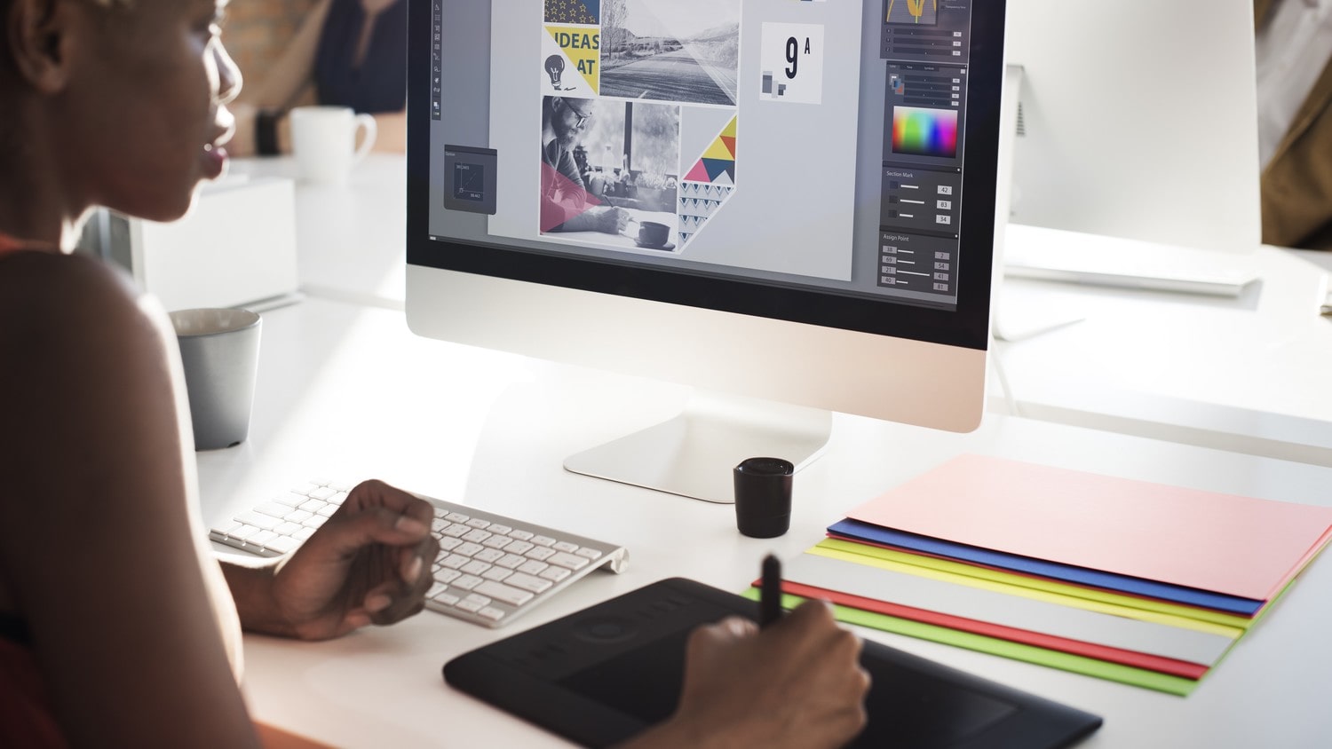 A graphic designer, working and designing a new logo on her computer.