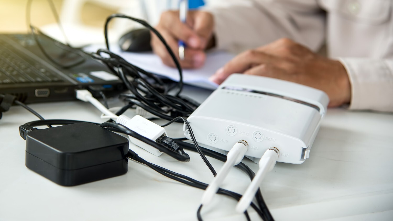 Close up of a man doing checks on wifi with laptop and testing tools