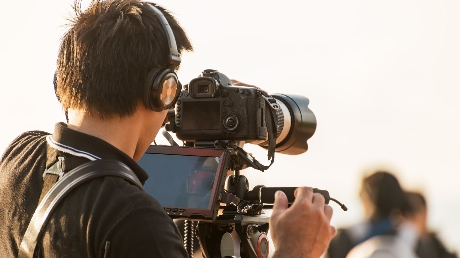 A camera man with headsets, filming
