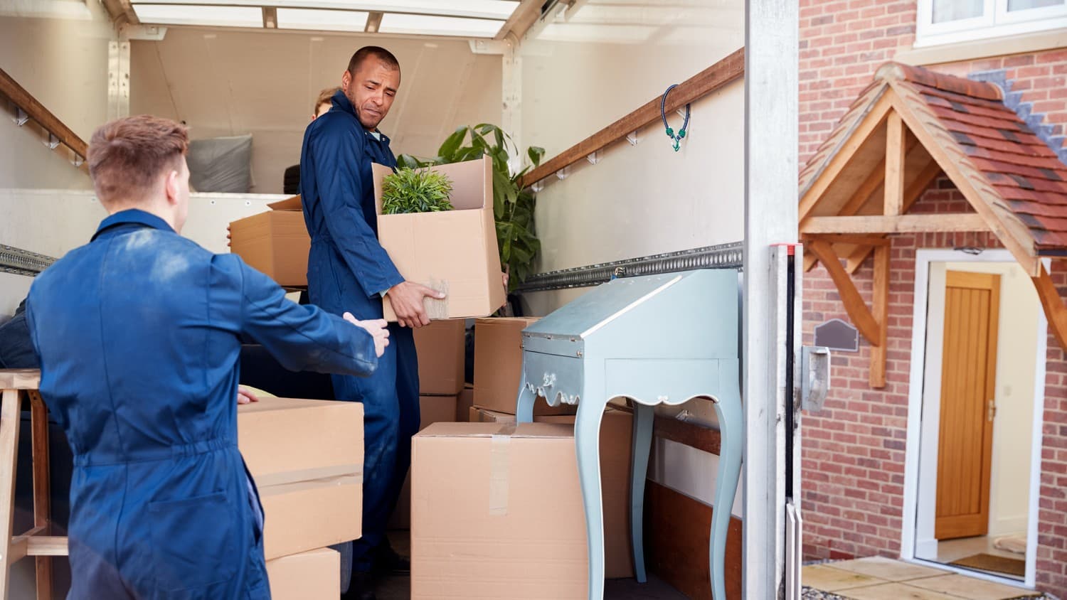 A moving truck parked in front of a house, ready to transport furniture and belongings to a new location.