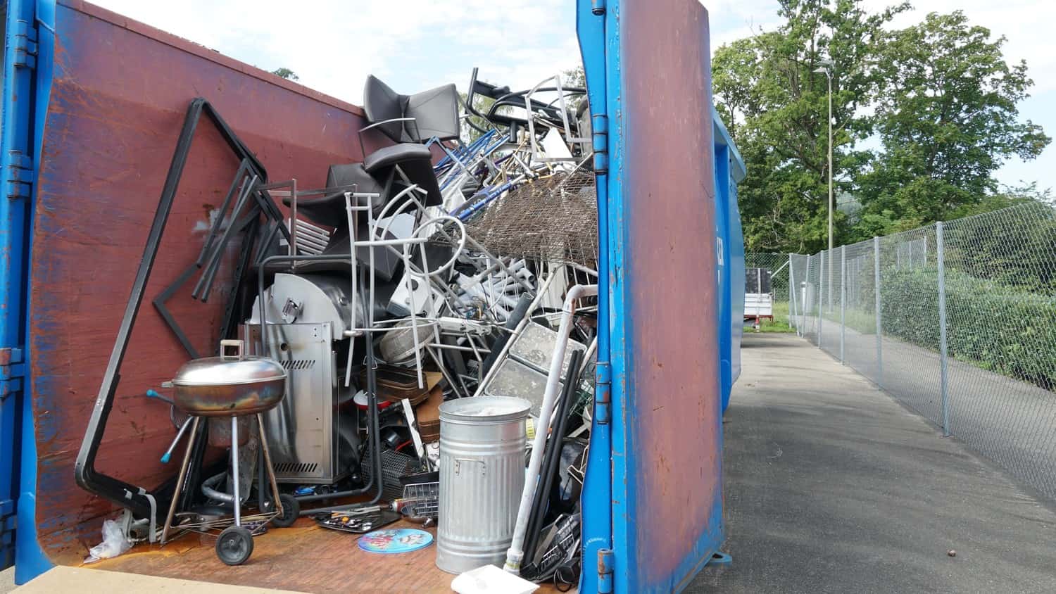 A pile of scrap metal ready for removal, consisting of various shapes and sizes, on a back of a truck.