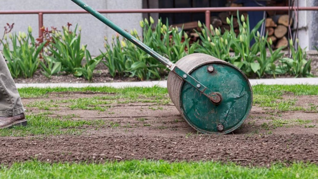 A person using a level to ensure a surface is even and flat, with tools and materials nearby.