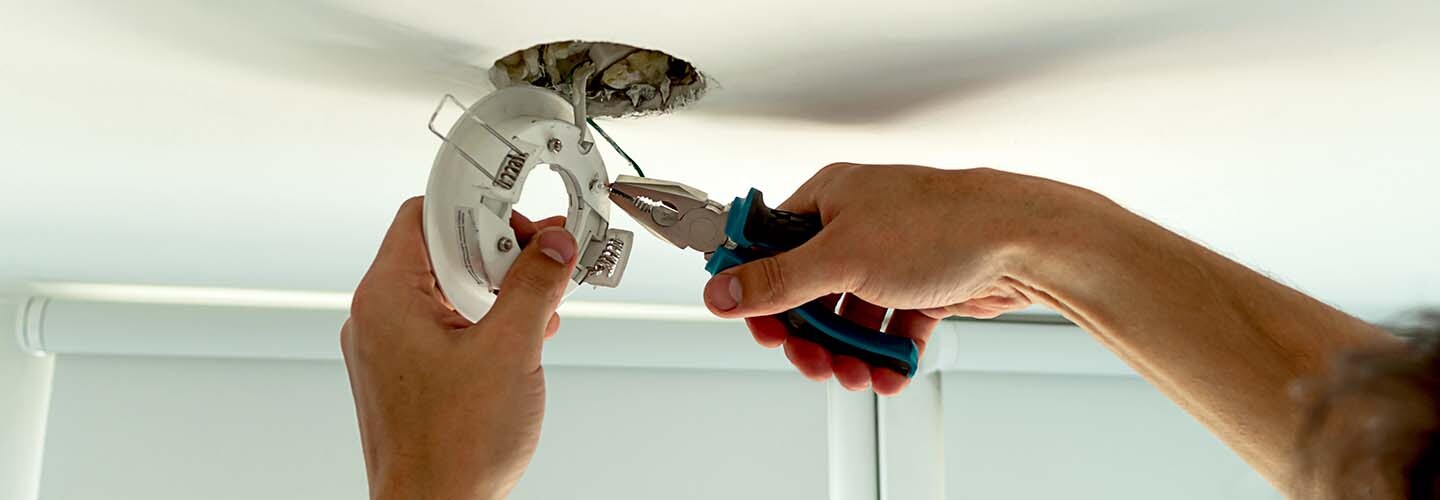 A close-up of a person installing a new light bulb.