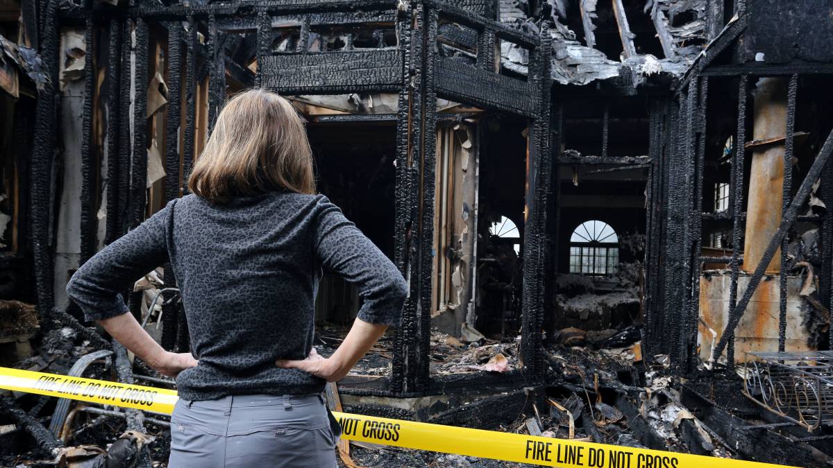 woman looking at her burnt house