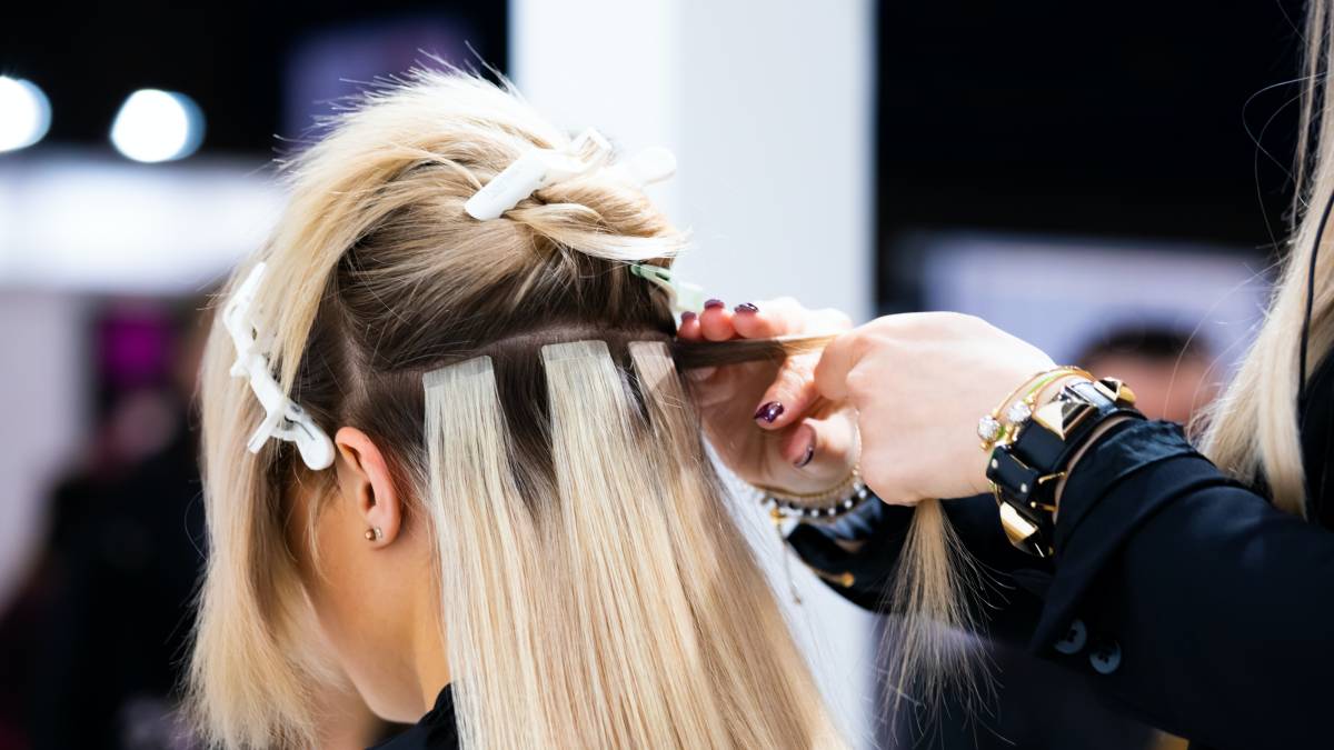 Hair stylist holding customer's hair extensions