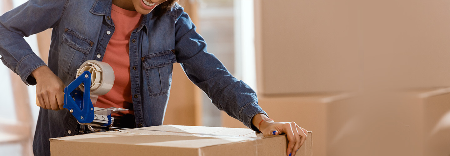 A professional packe carefully arranging and packing household items into boxes for a smooth and efficient move.