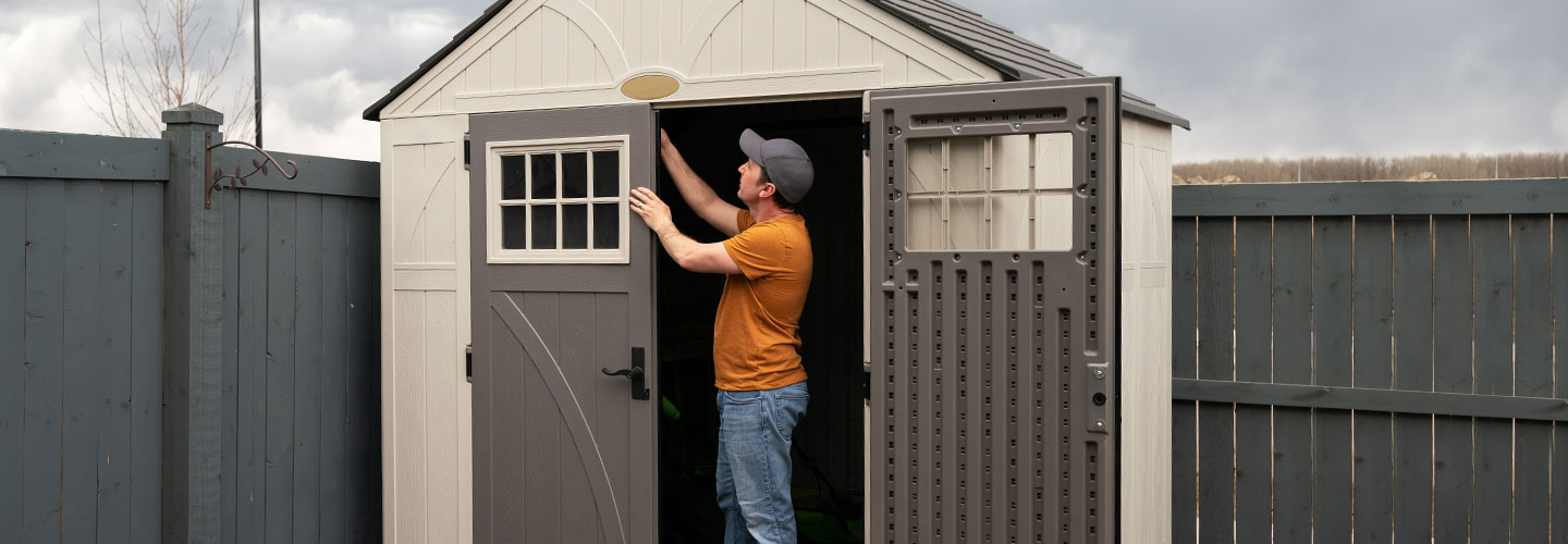 A person inside a shed checking the doors.