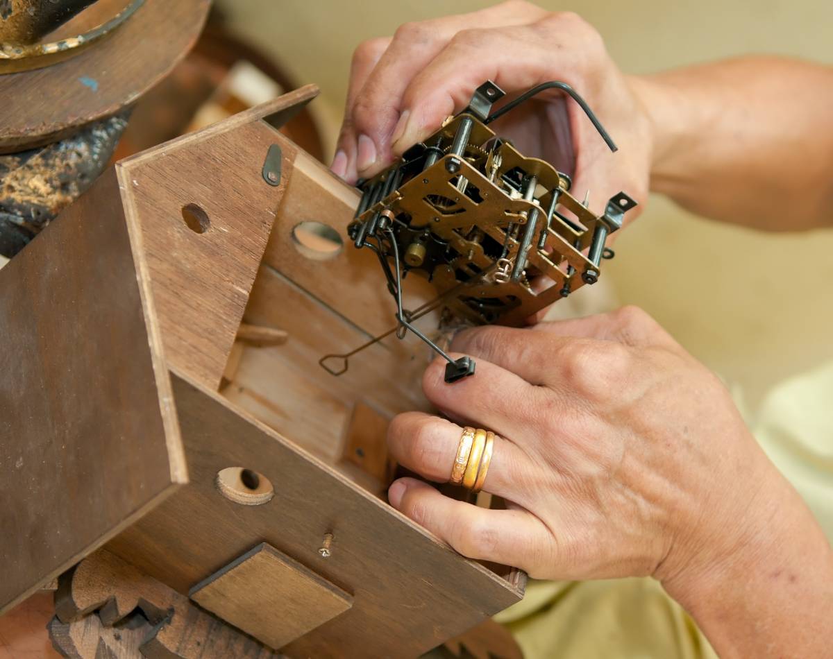 a handyman repairing a cuckoo clock
