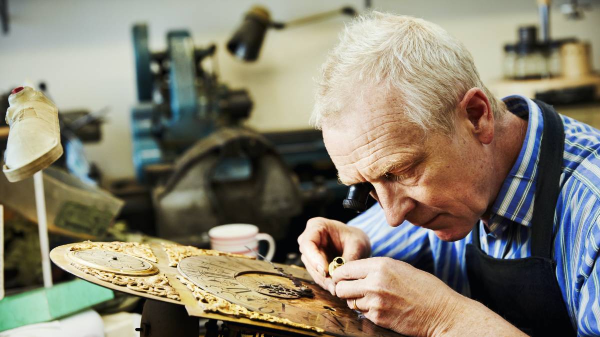 a handyman repairing a clock face