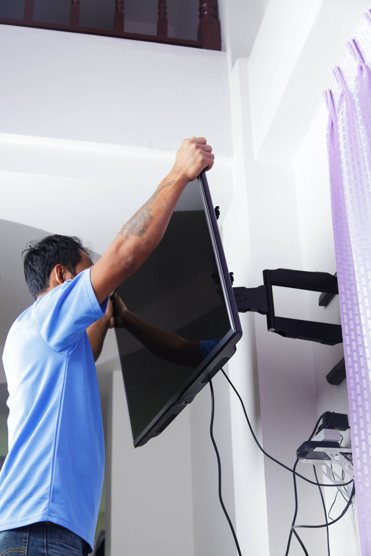 a handyman mounting a TV on a wall