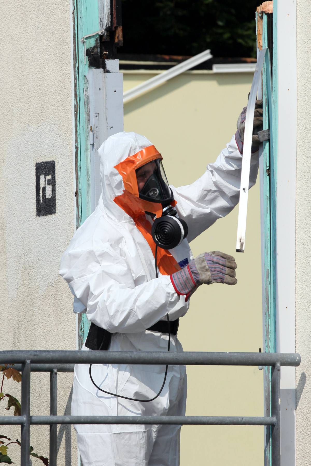 Man in PPE removing asbestos