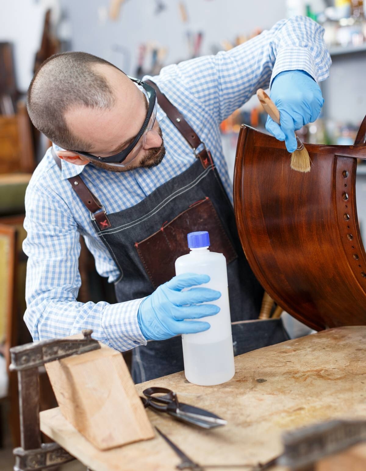 a man refinishing a wooden chair