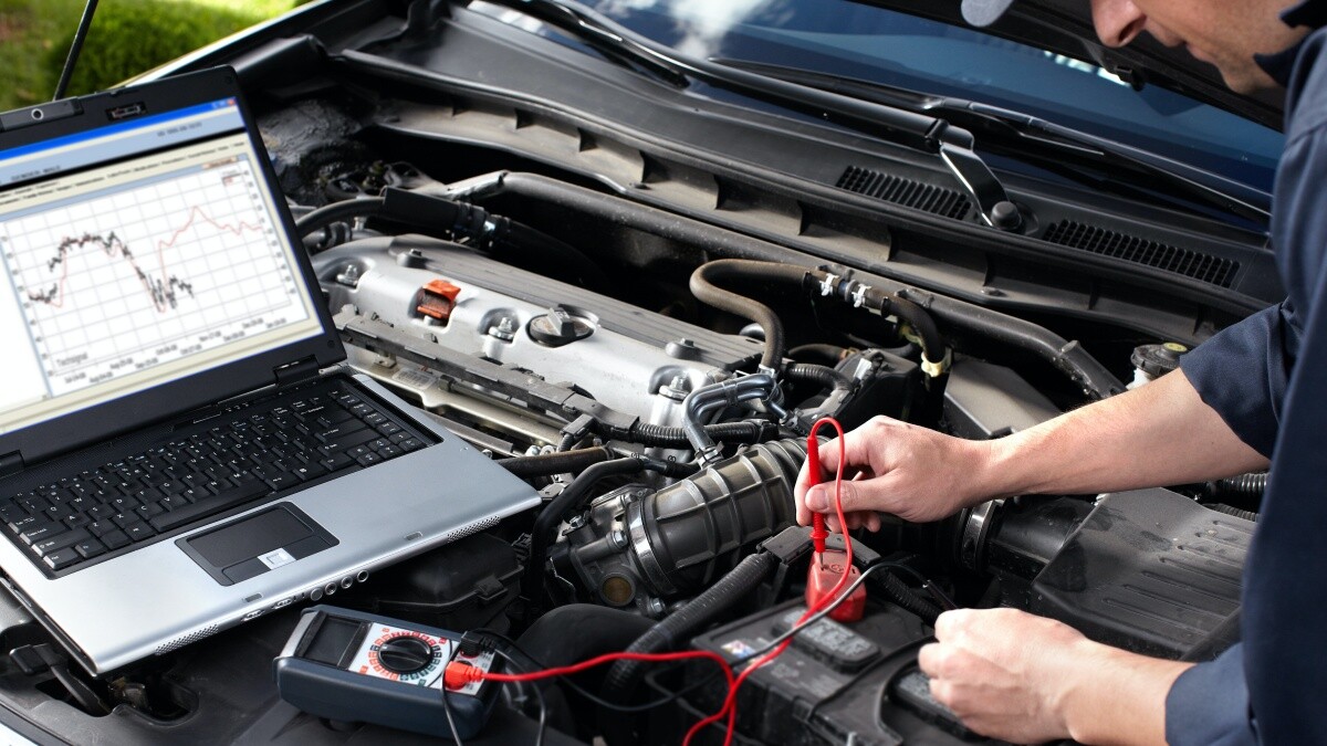 mechanic using computer to diagnose car problem