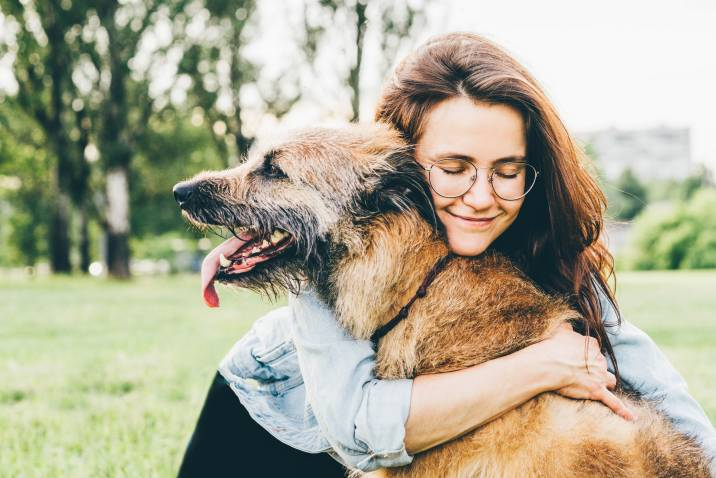cheerful woman hugging her senior dog