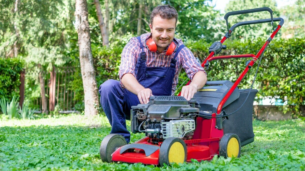 man repairing lawn mower