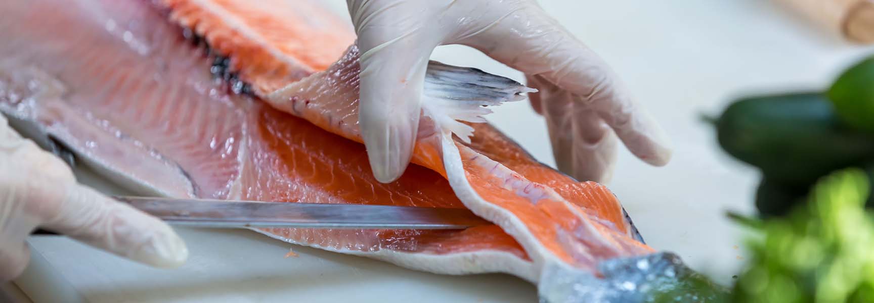 A skilled sushi chef expertly fillets a fish showcasing their precision and attention to detail.