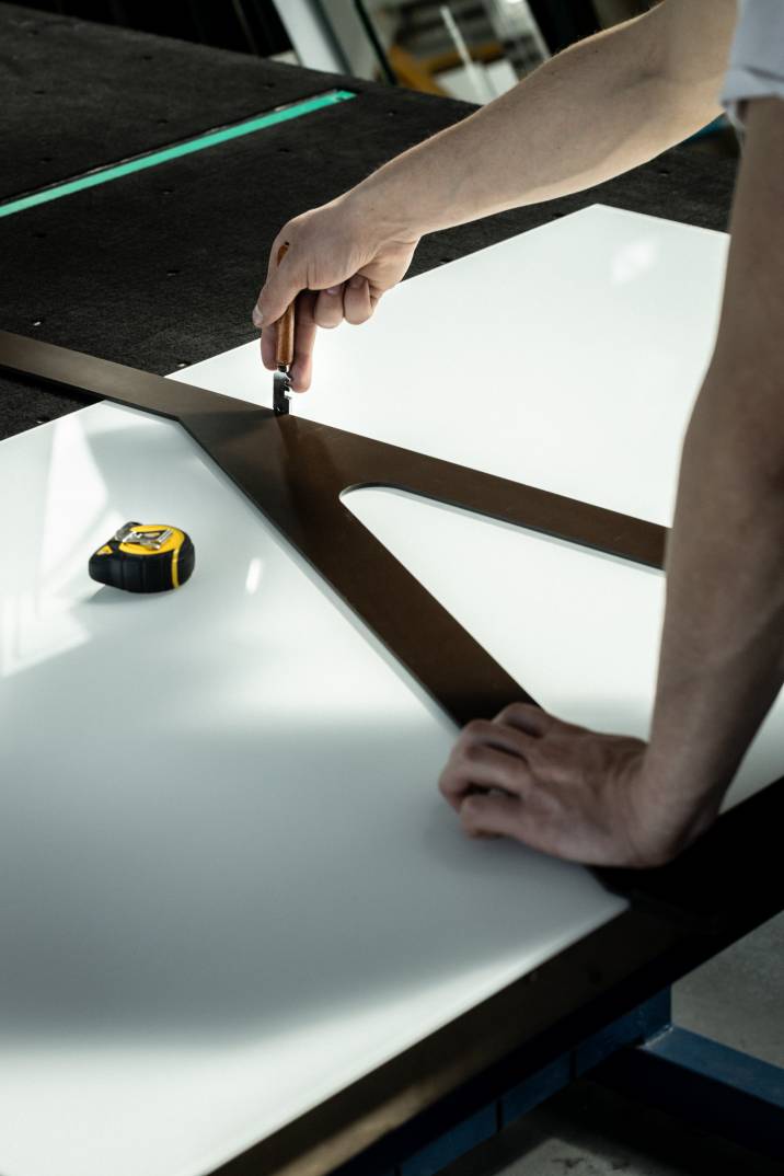 a craftsman cutting a large sheet of glass