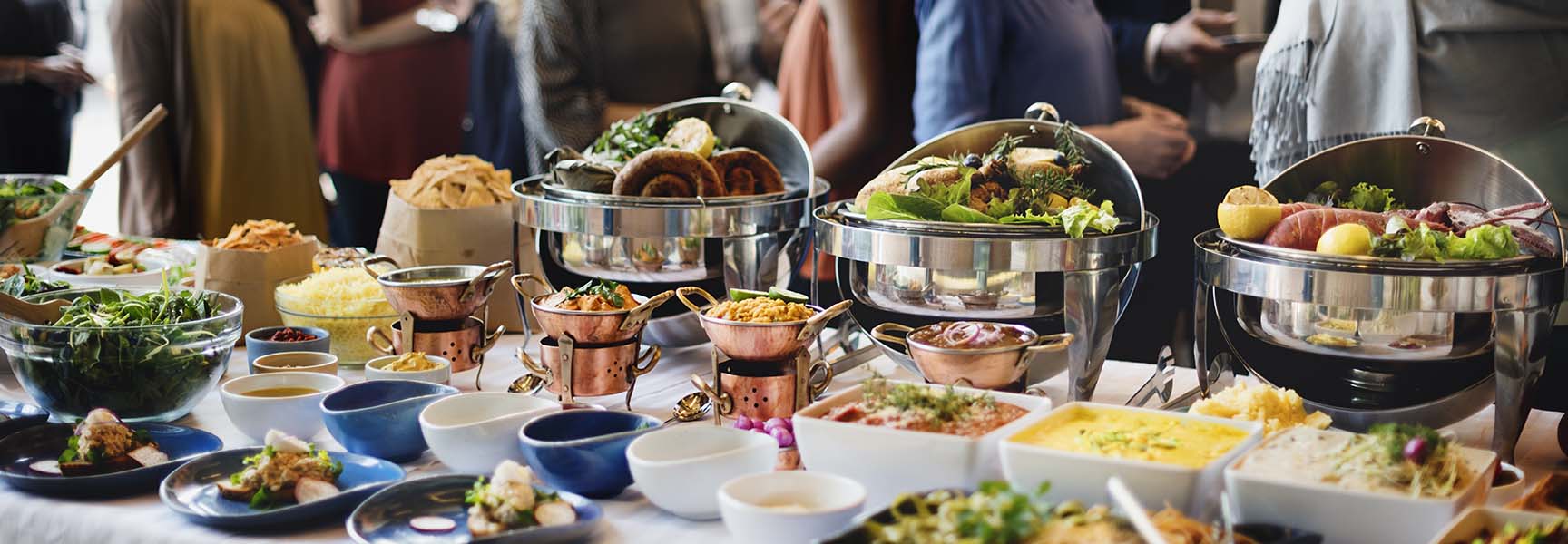 A colorful spread of delicious party catering food, including sandwiches, salads, fruits, and desserts, beautifully arranged on a table.