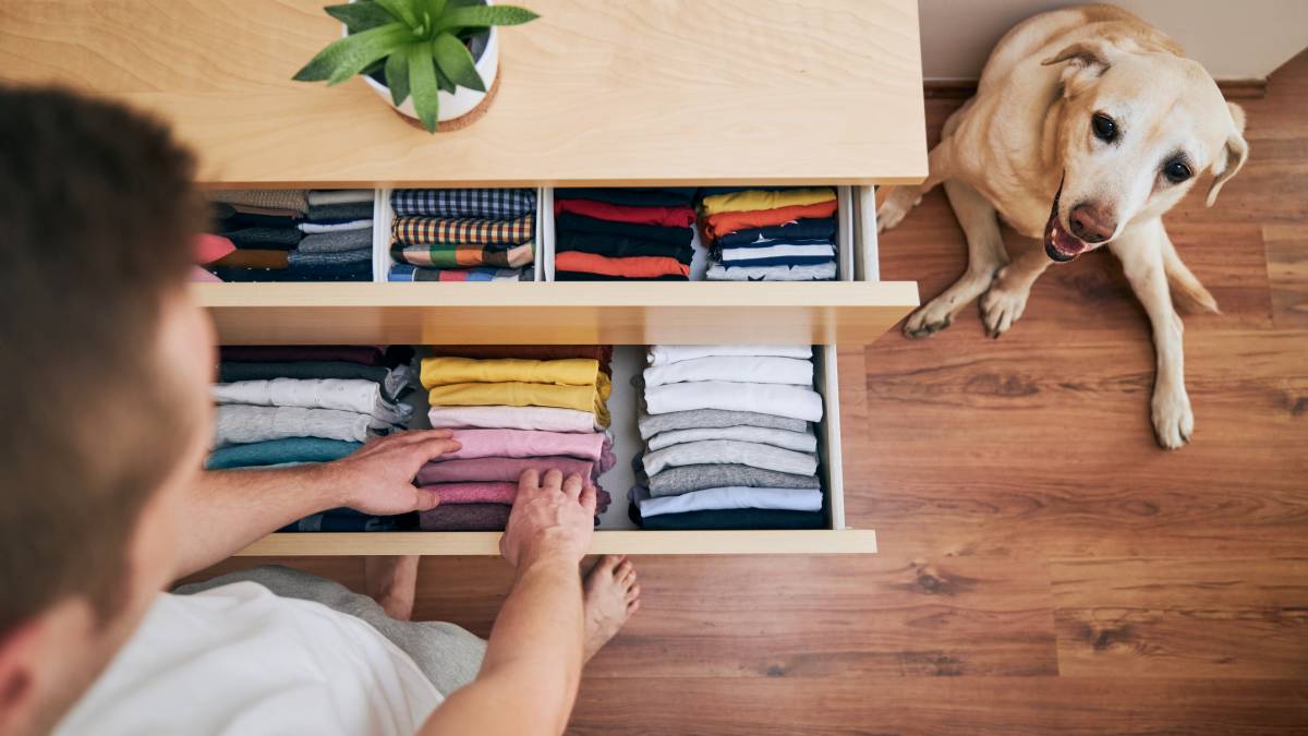 a man organising clothes in a drawer