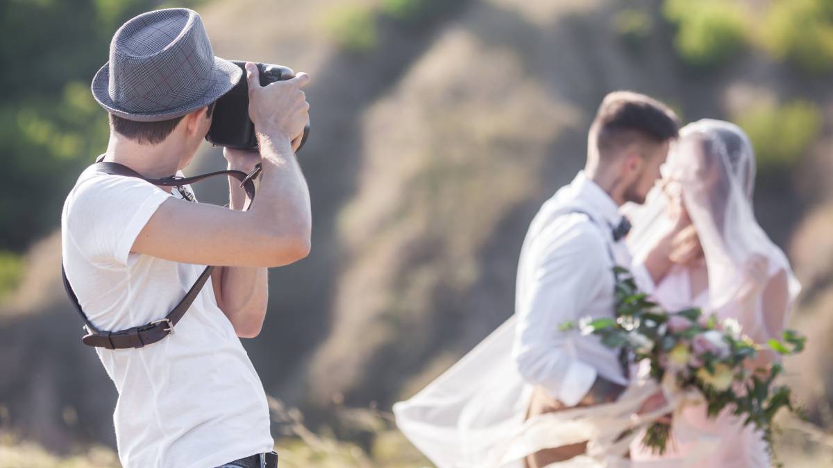 professional wedding photographer taking photos of newly wed couple