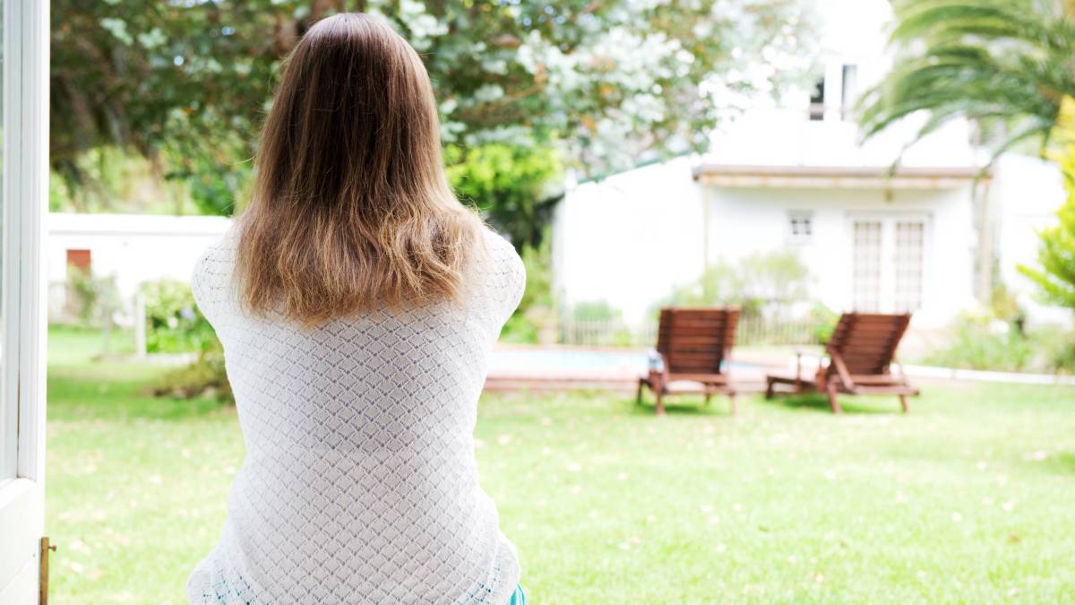 woman facing the yard while house sitting