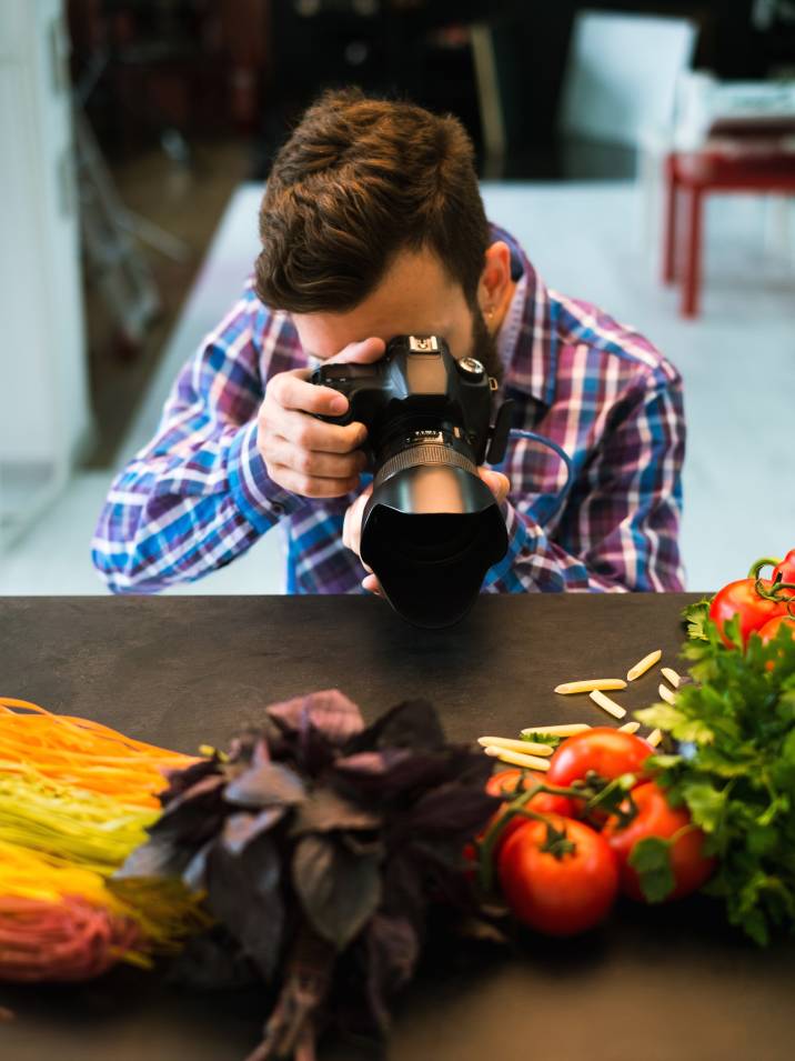 a man taking close-up pictures of vegetables