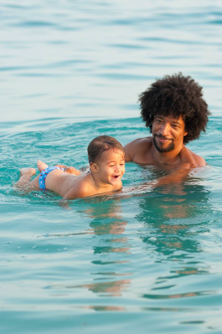 a man giving swimming lessons to a toddler