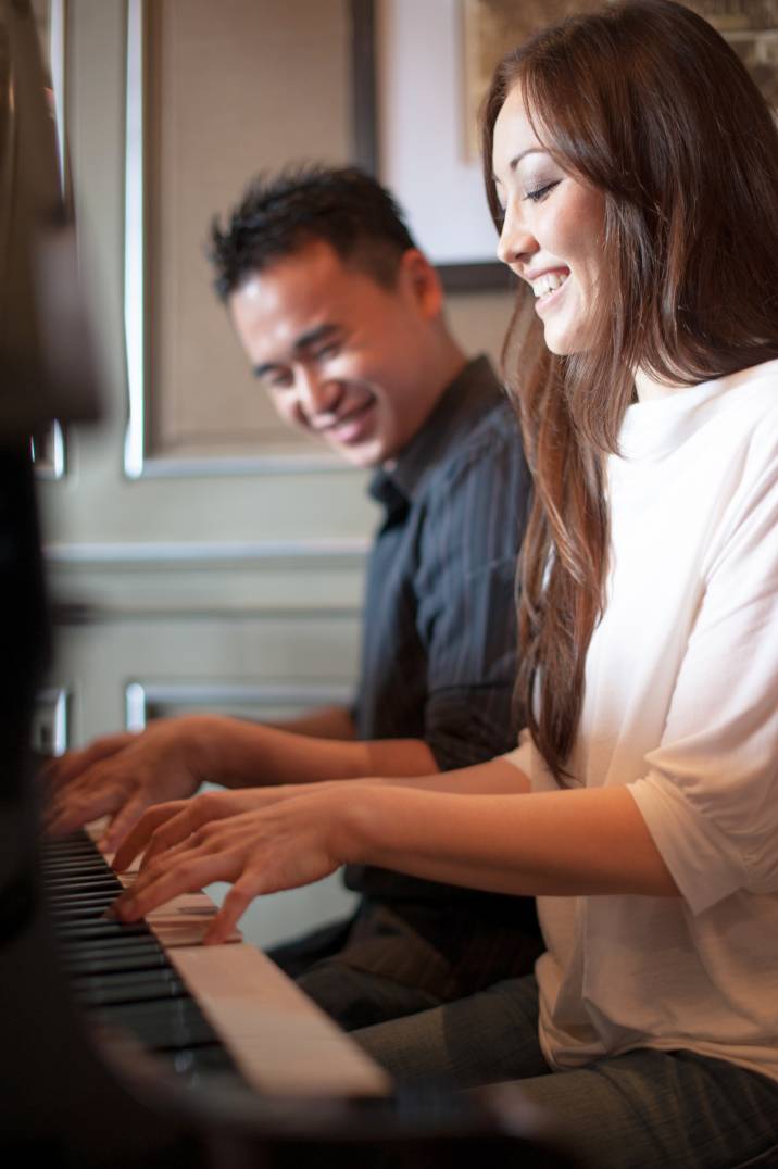 a man giving a woman a piano lesson