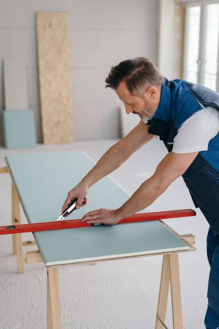 a handyman cutting sheets of wall cladding