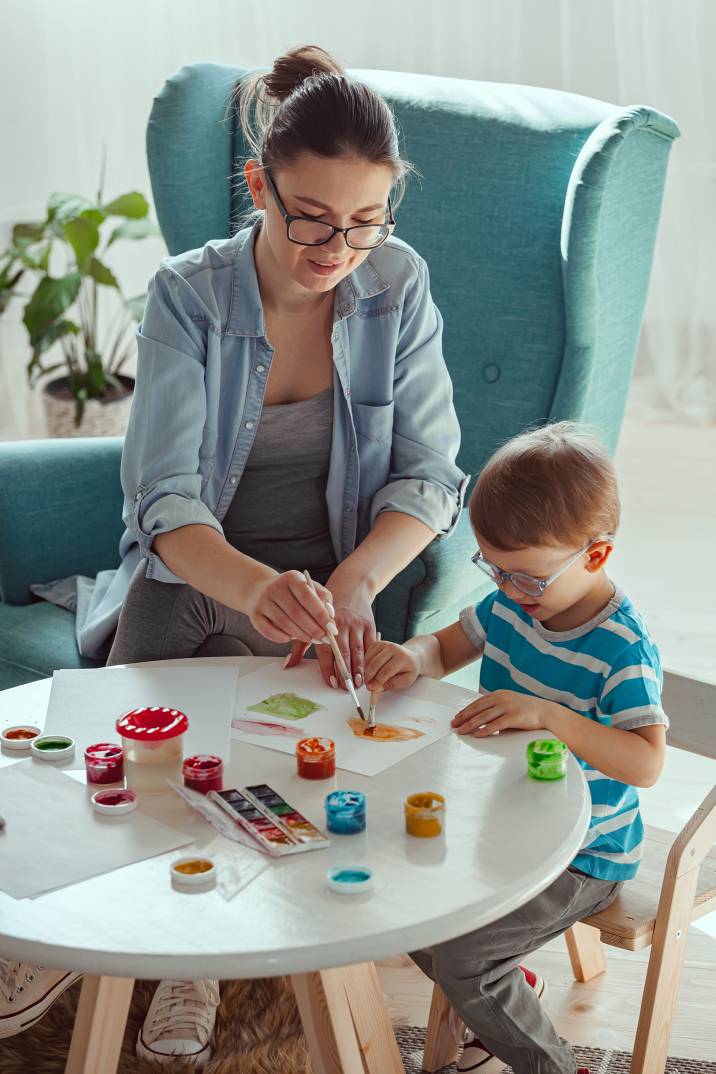 a nanny painting with a little boy