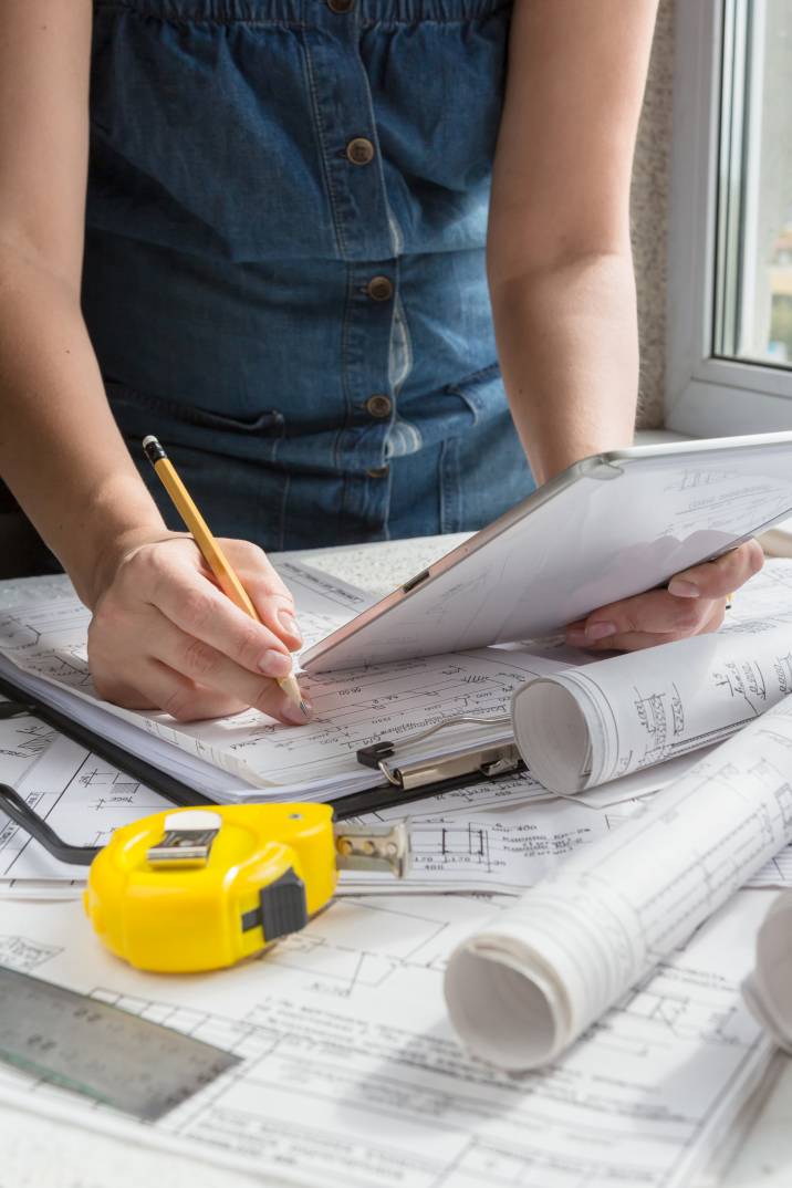 a female architect writing something on a clipboard