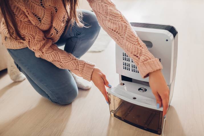 a woman setting up a dehumidifier