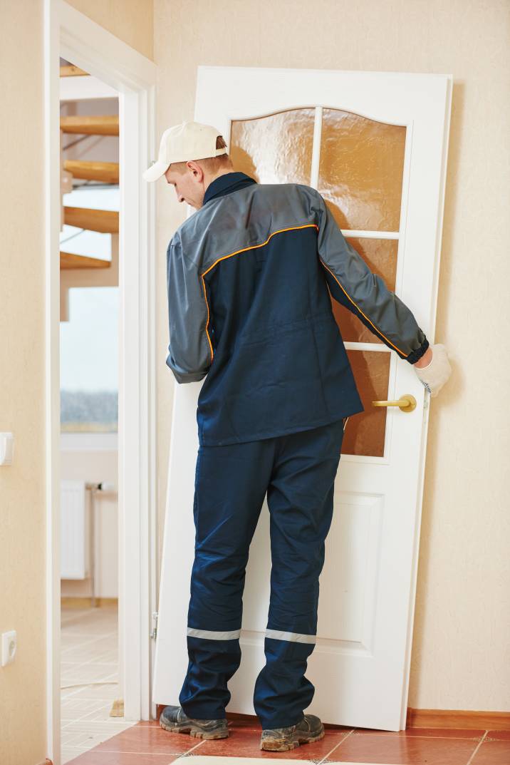 a handyman installing a wooden door