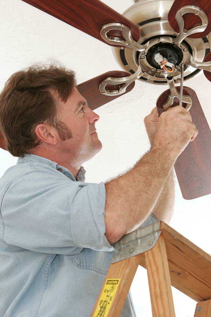 a man repairing a ceiling fan