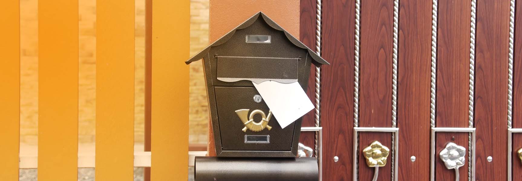 A close-up photo of a letterbox with a new letter in it.