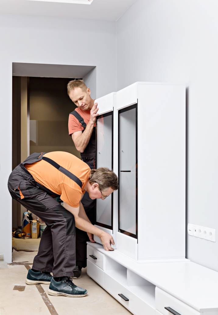 two handymen moving a large cabinet