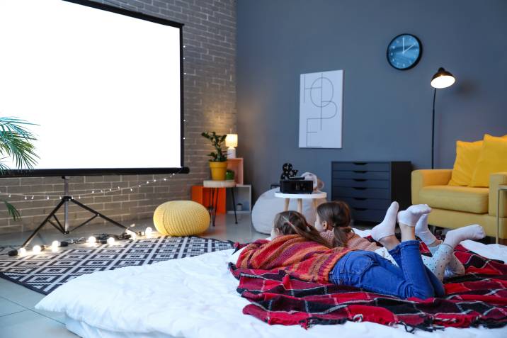 two little girls watching a movie in a garden room home theatre