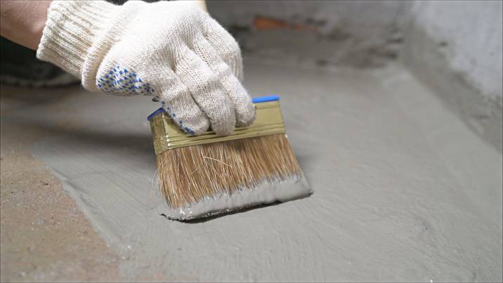 a man waterproofing a floor