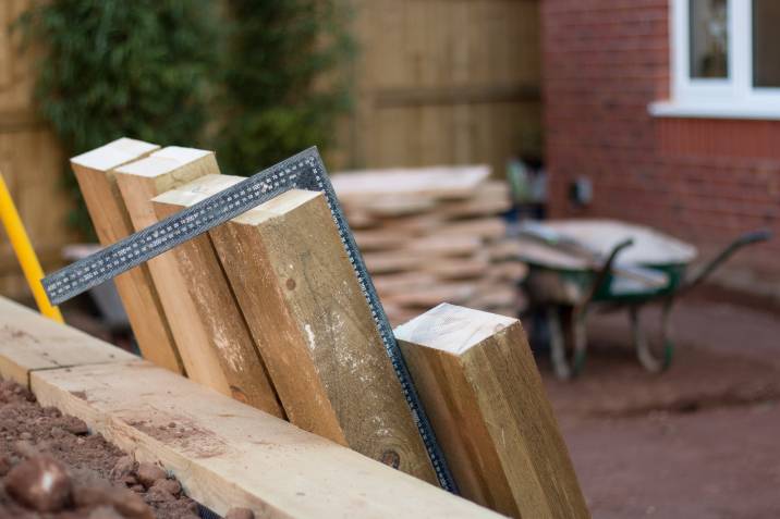 measuring wooden sleepers for a flowerbed