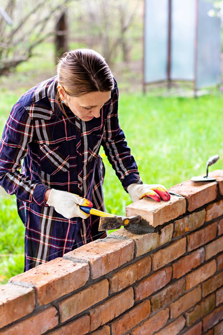 a woman building a garden wall