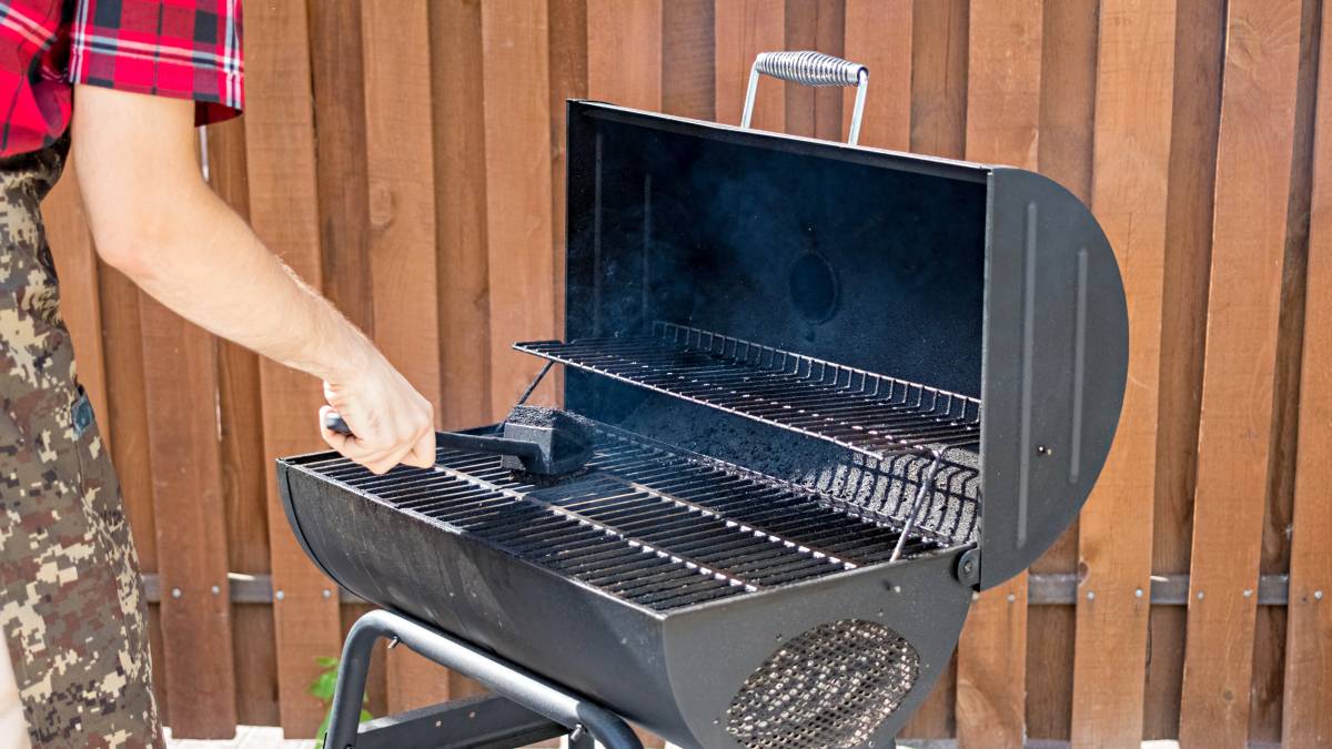 man cleaning barbecue grill