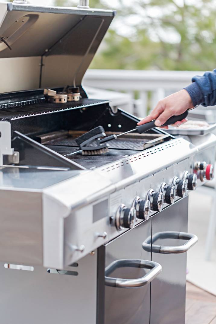 a man cleaning a barbecue grill