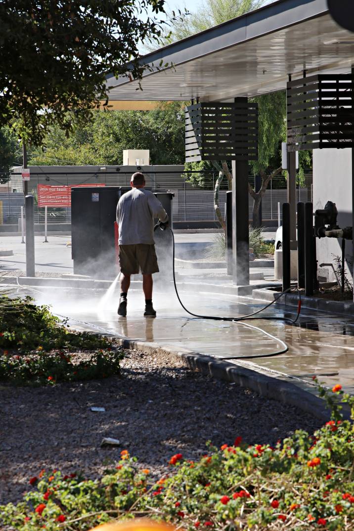 a man cleaning a driveway with a pressure washer