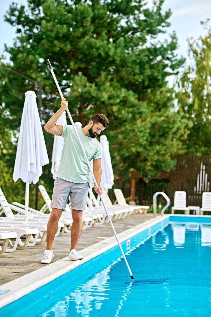 a man cleaning a swimming pool
