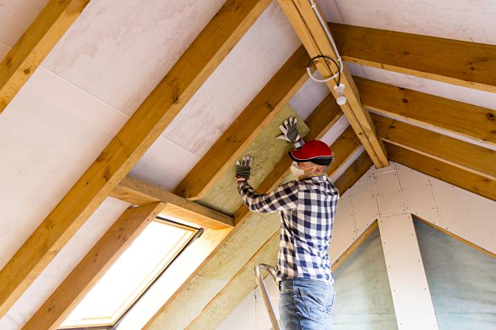 a man installing new attic insulation