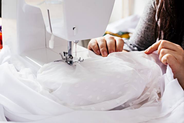 a seamstress altering a wedding dress
