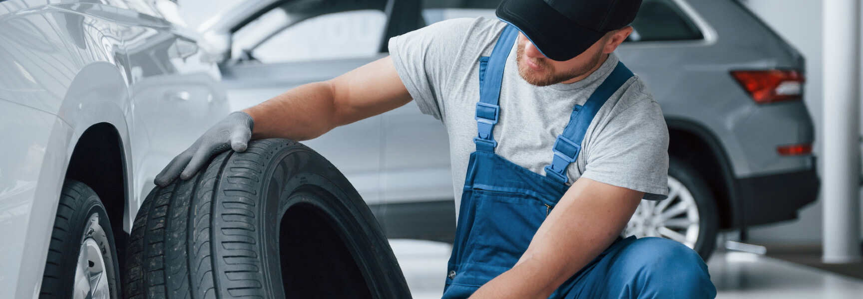 A close-up photo of a person replacing a car tire.