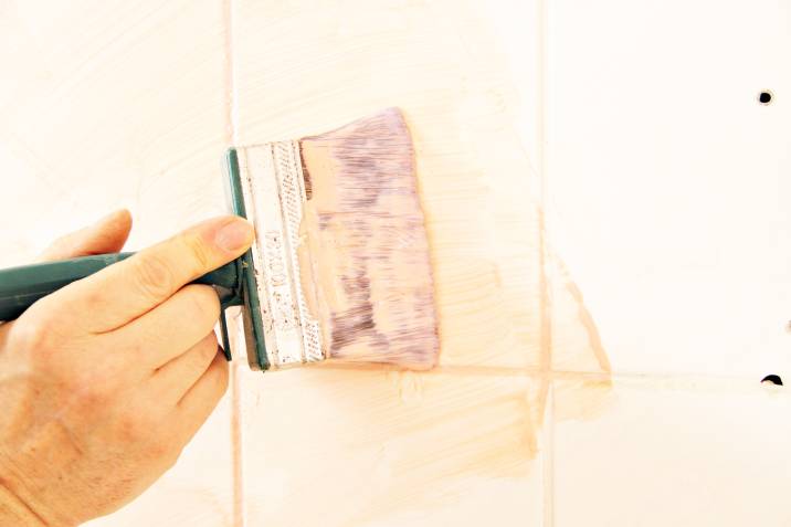 a man painting bathroom tiles